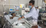 Bác sĩ Huy đang thăm khám cho anh Tám tại khoa hồi sức cấp cứu Bệnh viện Chợ Rẫy. Ảnh: Quốc Ngọc.