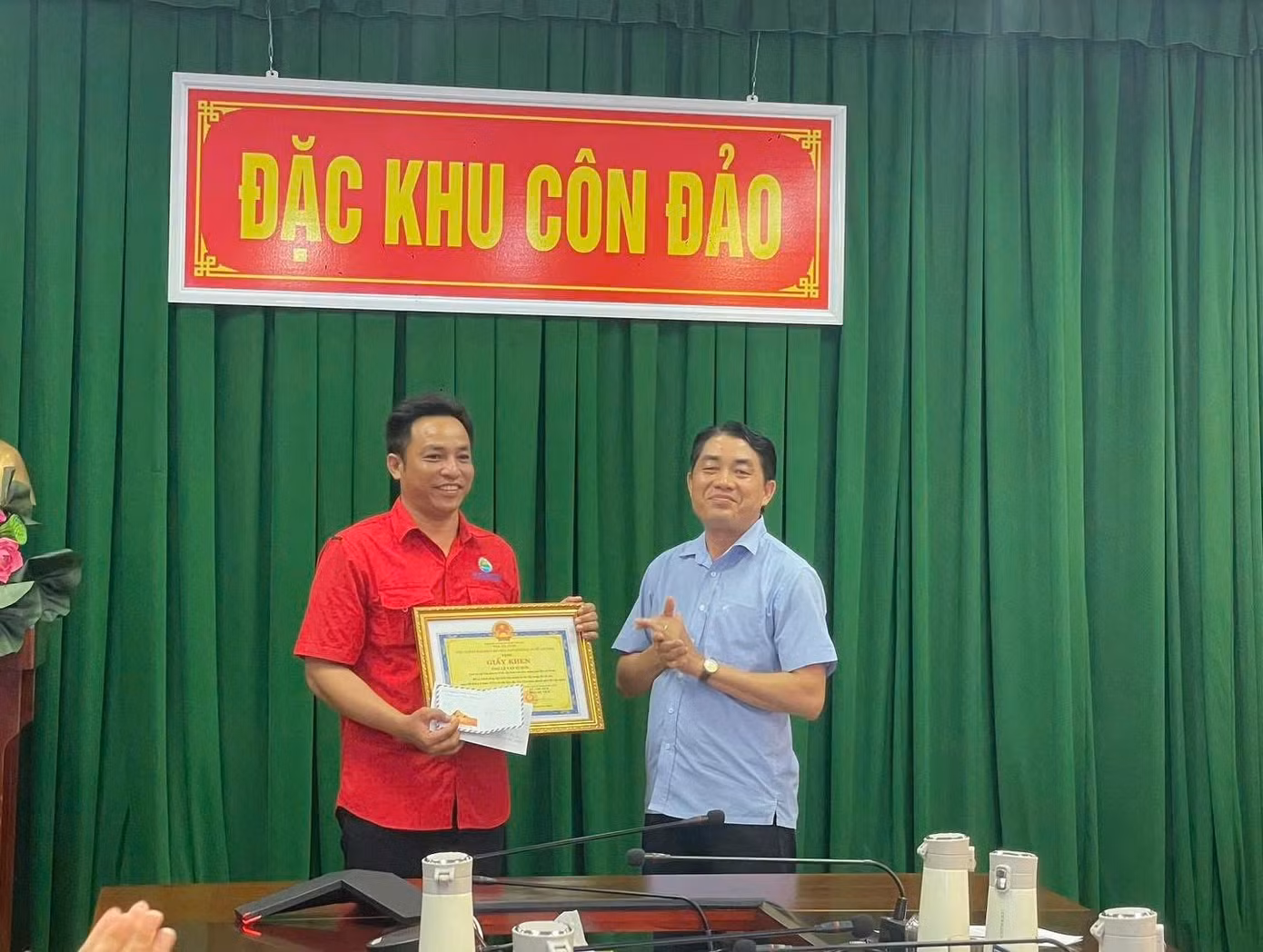 Ông Nguyễn Văn Mạnh, Phó Chủ tịch Đặc khu Côn Đảo (phải) trao giấy khen cho anh Lê Văn Tí Hon. Ảnh: P.M