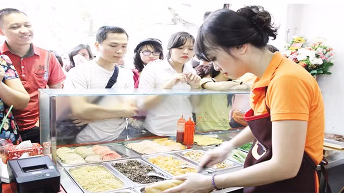 Minh Nhật tất bật trong ngày khai trương cửa hàng bánh mỳ. Ảnh: TL.
