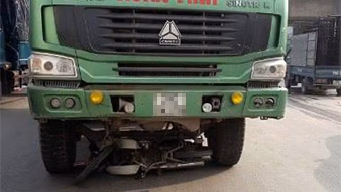 Chiếc xe máy vẫn nằm gọn dưới gầm xe tải.