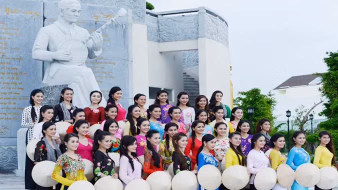 Các thí sinh trước tượng nhạc sỹ Cao Văn Lầu, tác giả bài Dạ cổ hoài lang. Ảnh: Nguyễn Sơn