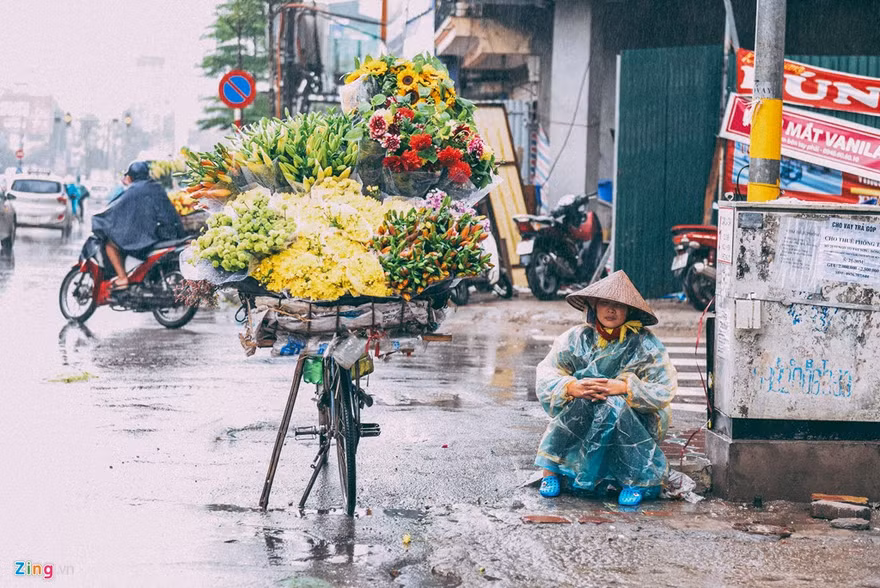 Ba ngày nay, không khí lạnh tăng cường khiến Bắc Bộ mưa rét, tuy nhiên nhiều người vẫn ra đường mưu sinh khi nhiệt độ giảm còn 15 độ C. Một người bán hoa dầm mình giữa mưa chờ người mua