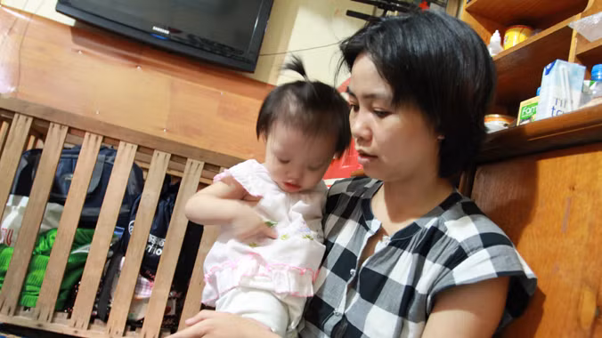 Chị Phương, vợ đại úy Tâm cùng cháu nhỏ tại nhà trọ. ảnh: Minh Đức