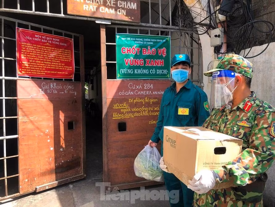 Lực lượng chức năng đi chợ hộ cho người dân trong thời gian giãn cách xã hội (ảnh: Uyên Phương)