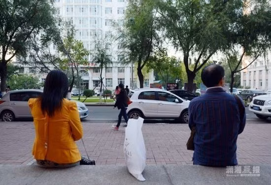 Cha mẹ Chen ngồi bên ngoài trường chờ con