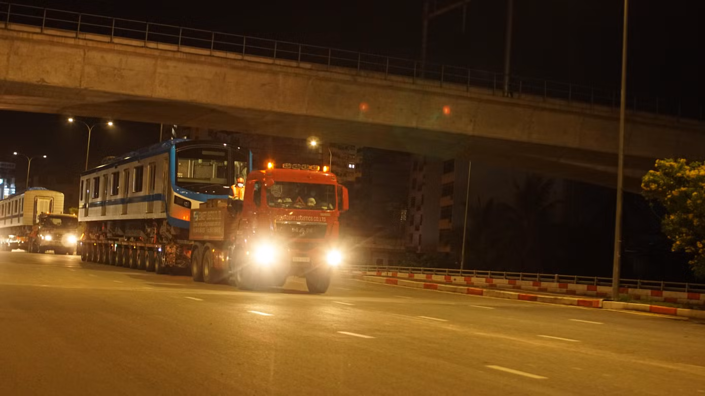 Đoàn xe chở tàu metro chuẩn bị rẽ vào vào depot Long Bình