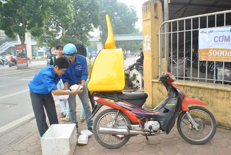 Các tình nguyện viên CLB Hope mang cơm đến cổng trường 