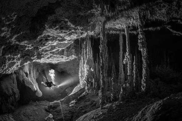 Bức ảnh của nhà nhiếp ảnh Mexico Tom St George, chiến thắng trong hạng mục Ocean Adventure Photographer of the Year tại cuộc thi Ocean Photographer of the Year 2022. Một thợ lặn khảo sát hệ thống hang động dưới nước, được bao quanh bởi những cấu trúc khổng lồ đã mất hàng thiên niên kỷ để hình thành.