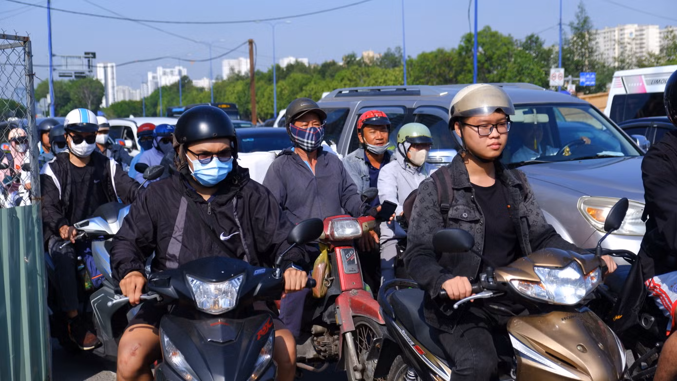 Thời tiết nắng nóng gay gắt, người dân "mướt mồ hôi" di chuyển qua khu vực nút giao giữa đường Mai Chí Thọ với đường Đồng Văn Cống.