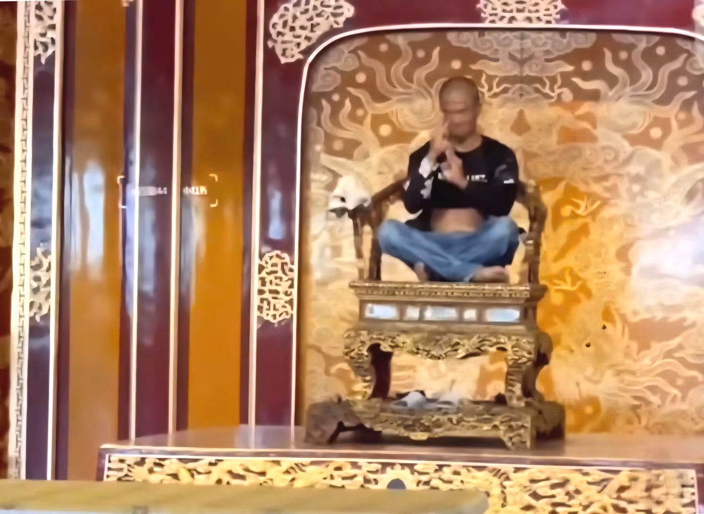Đối tượng Hồ Văn Phương Tâm ngồi lên ngai vàng trong Đại Nội Huế và xâm hại Bảo vật quốc gia này. Ảnh chụp màn hình.