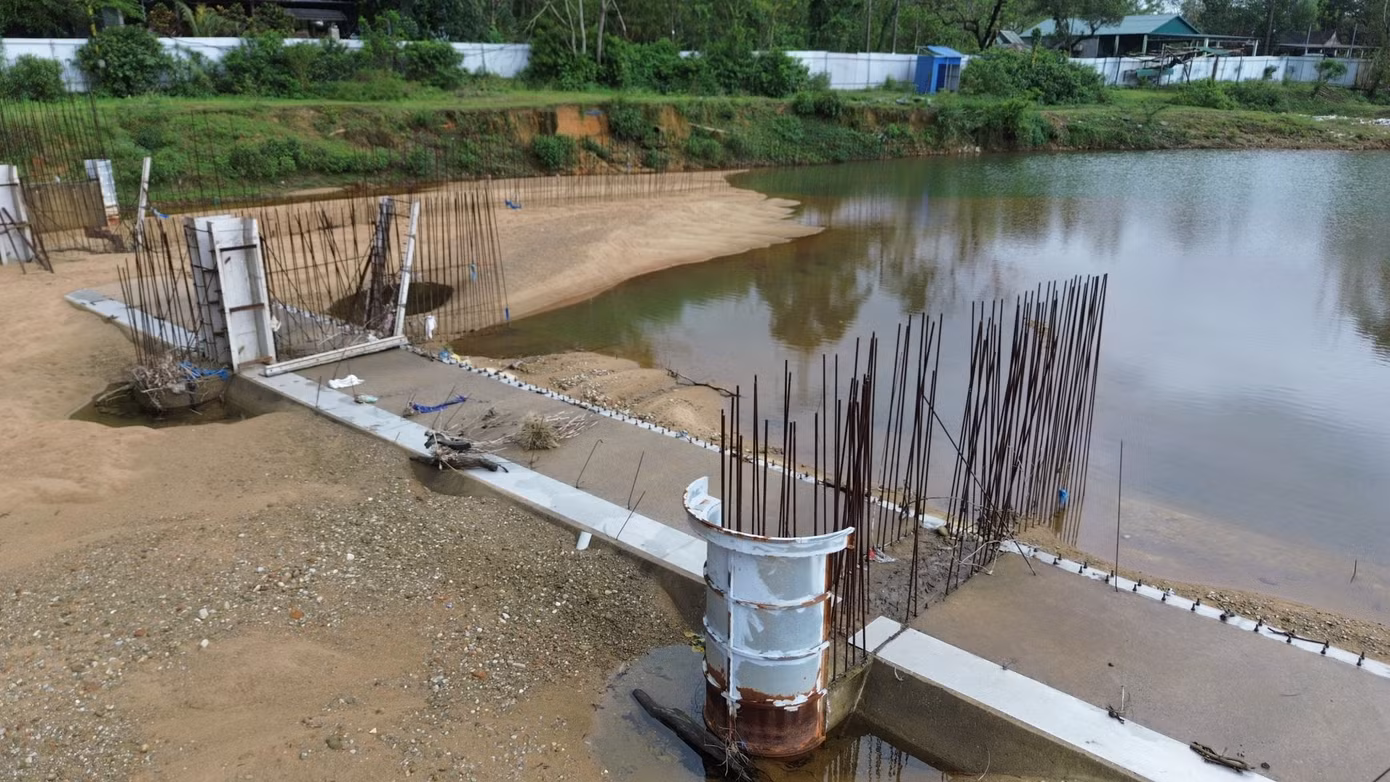 Hạng mục đập tràn vùng hạ lưu khe suối trong cảnh dang dở và chưa có dấu hiệu tái xây dựng trở lại.