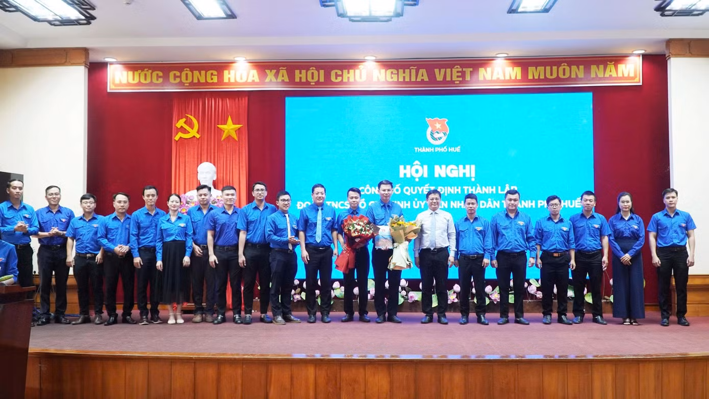 Phó Chủ tịch Thường trực UBND TP Huế Nguyễn Thanh Bình (áo trắng) trao quyết định và tặng hoa chúc mừng Ban chấp hành Đoàn TNCS Hồ Chí Minh UBND thành phố. Ảnh: Lê Thọ