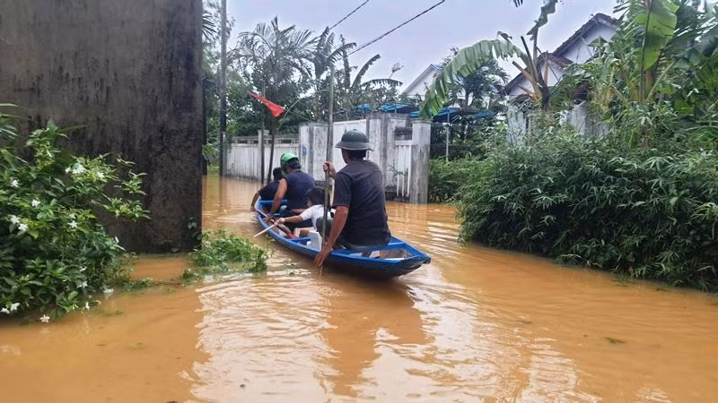 Người dân di chuyển bằng ghe thuyền trên con đường ngập. Ảnh: N.V