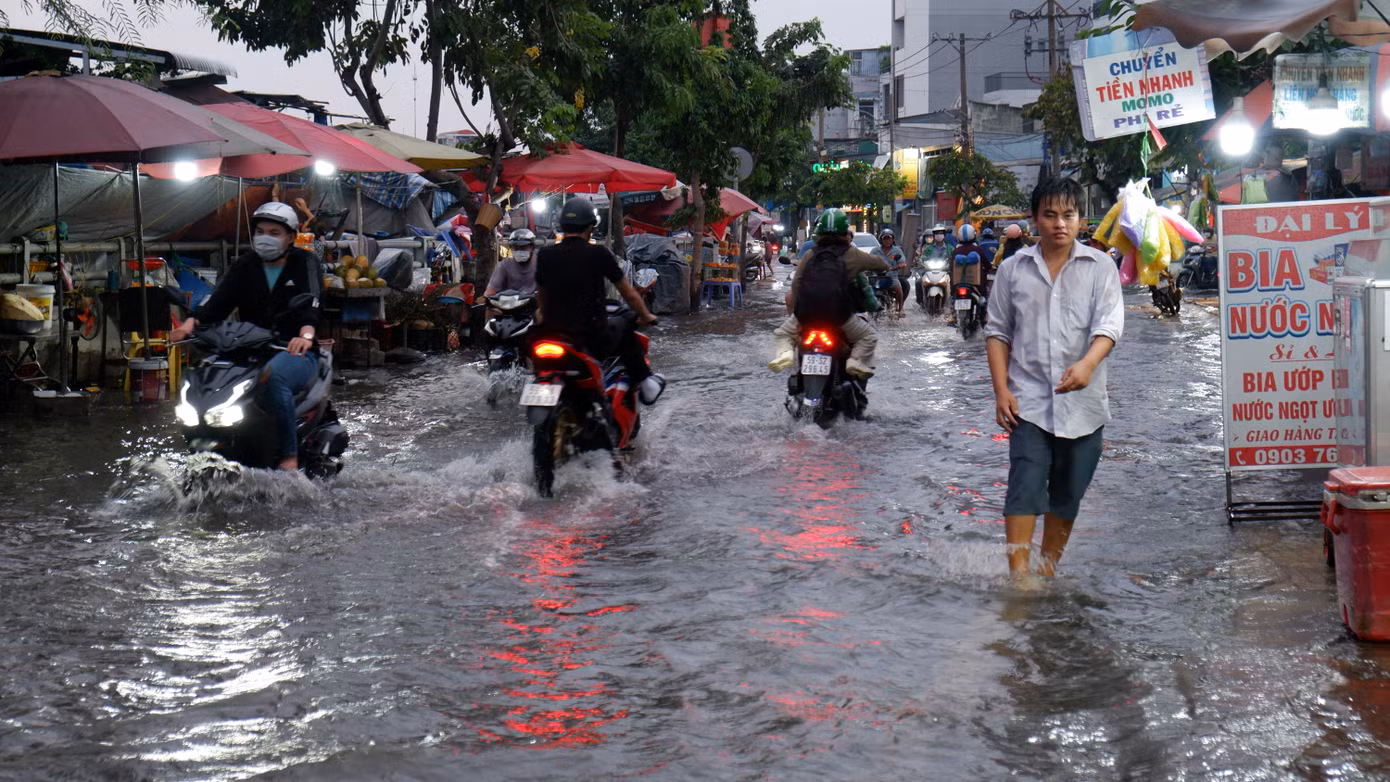 Người dân bì bõm lội nước trên đường Trần Xuân Soạn (quận 7) khi triều cường dâng cao vào chiều tối 3/11. Ảnh: Hữu Huy