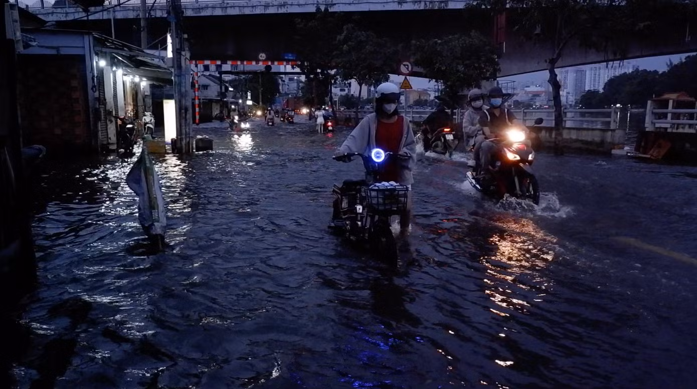 Người dân bì bõm lội nước dắt xe bị chết máy trên đường Trần Xuân Soạn.