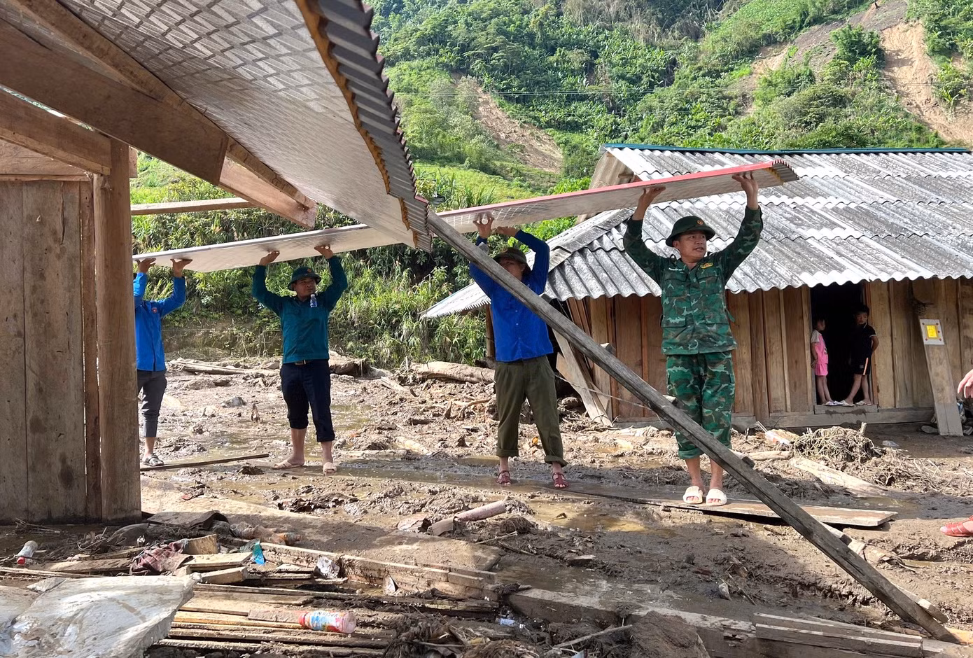 Hỗ trợ tháo dỡ mái tôn cho các hộ dân bị ảnh hưởng sau lũ.