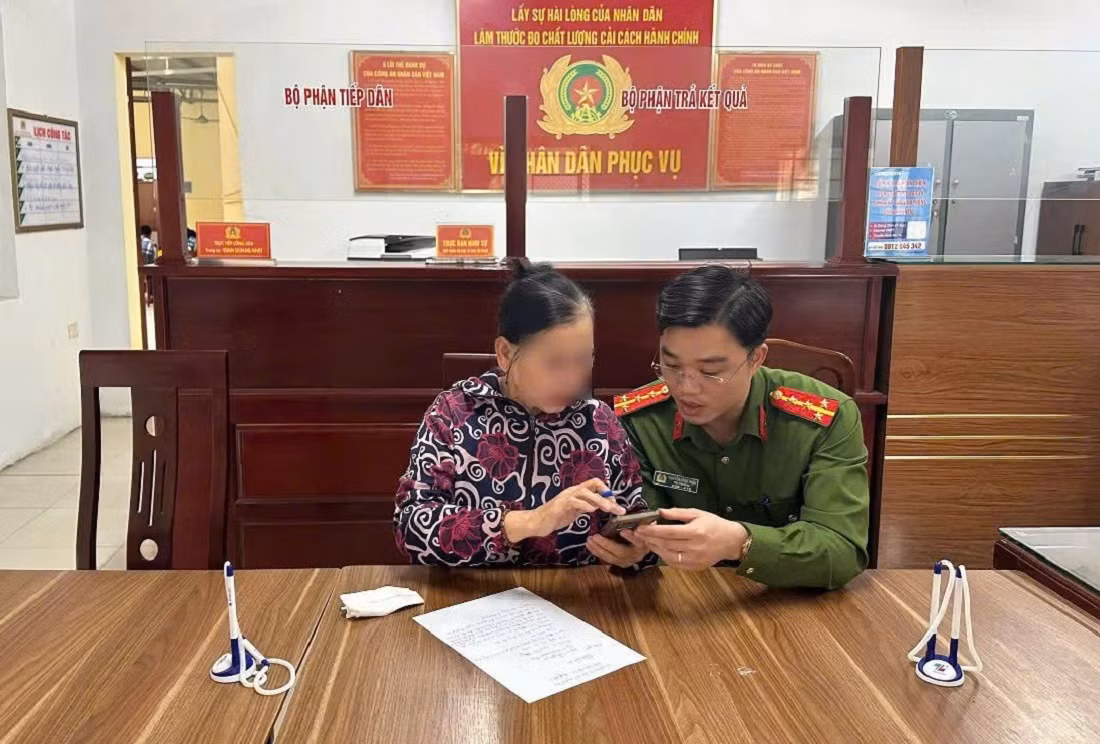 Đại úy Nguyễn Công Thận - Phó Trưởng Công an phường Quỳnh Thiện giải thích cho bà Tr. về việc bà bị lừa đảo.