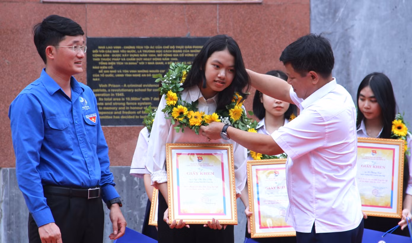 Ông Trần Quang Hòa và anh Trần Linh - Phó Bí thư Tỉnh Đoàn Nghệ An trao tặng Giấy khen, hoa tuyên dương các em học sinh tiêu biểu.