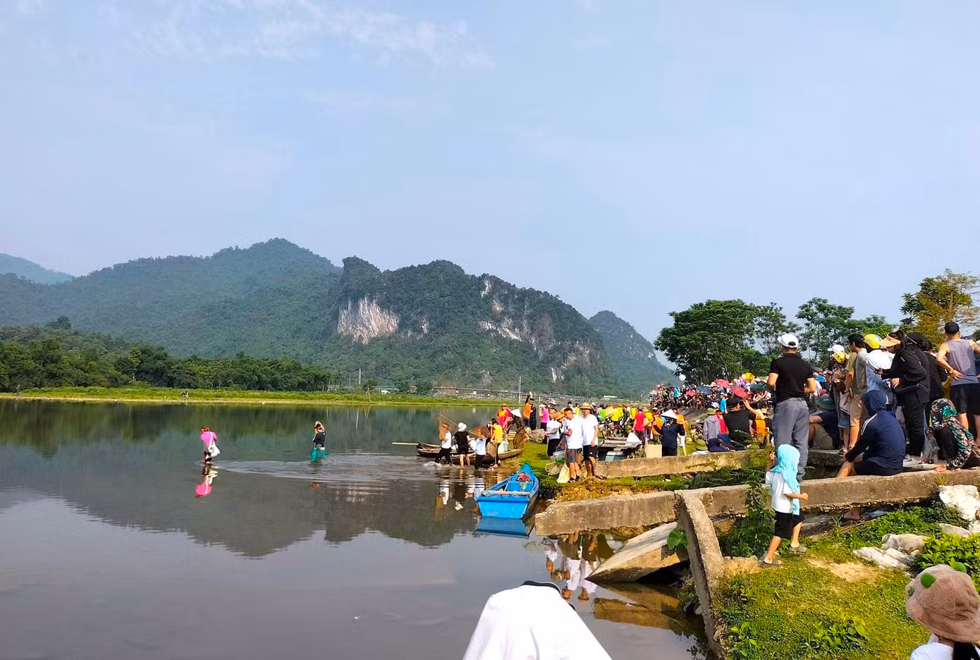 Ngoài các đội thi, trên bờ có cả nghìn người dân theo dõi cuộc thi và chờ đến lượt để được xuống sông tham gia bắt cá.