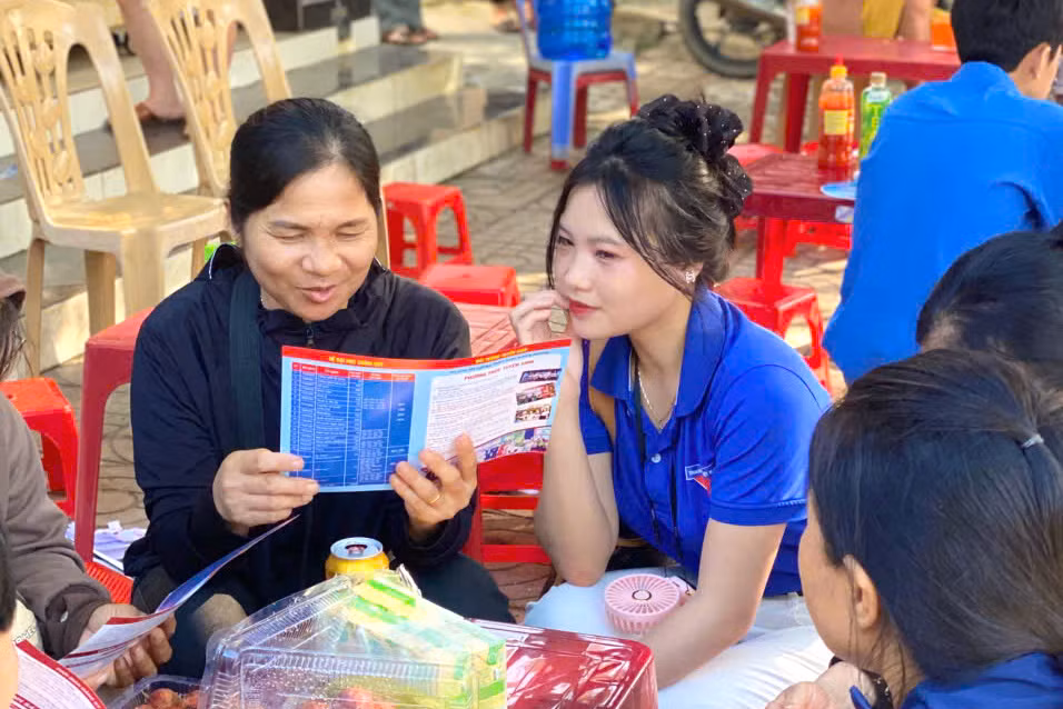 Những áo xanh tình nguyện trường Đại học Nghệ An tranh thủ giờ thí sinh làm bài đã tư vấn các ngành học cho phụ huynh học sinh.