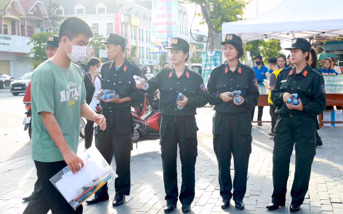 Các chiến sĩ Ban Thanh niên Công an tỉnh Nghệ An phát nước tiếp sức sĩ tử tại điểm thi trường THPT Huỳnh Thúc Kháng.