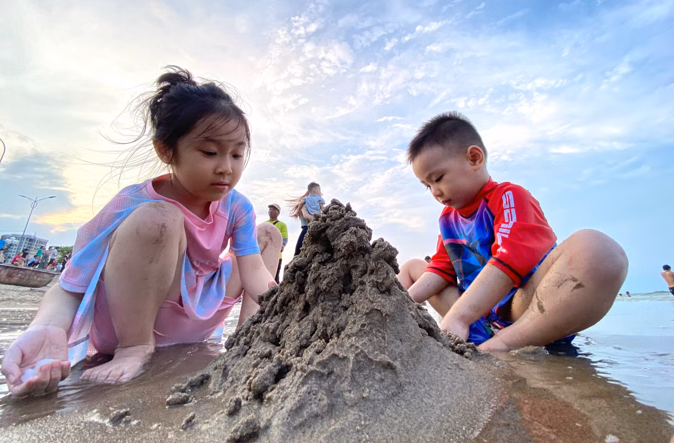Nhiều em nhỏ mải mê chơi đùa với cát.