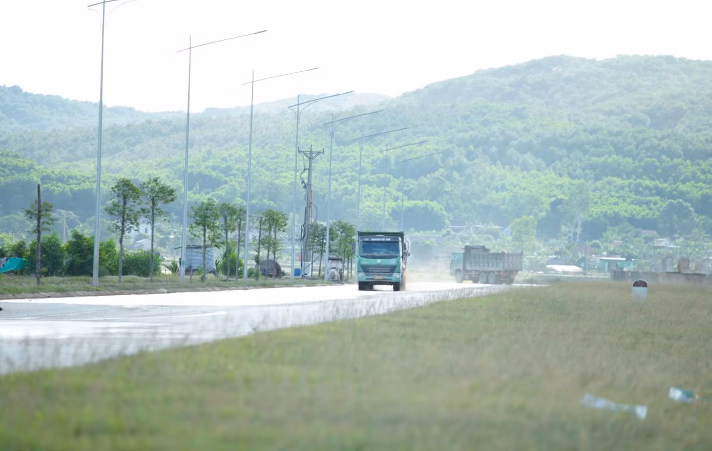 Xe ben vận chuyển vật liệu đi trên tuyến đường N2 khiến bụi bay mù mịt. Dù có xe tưới nước nhưng đất rơi vãi xuống càng khiến tuyến đường trở nên nhớp nhúa.