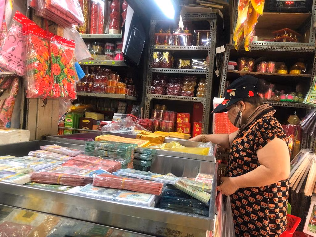 Ghi nhận tại nhiều quầy hàng kinh doanh vàng mã trong chợ, chủ hàng bày biện đủ các sản phẩm từ tiền vàng, giấy tờ, vàng nén, nhang, đèn… đến các sản phẩm hiện đại như nhà lầu, ô tô, thuyền rồng, trực thăng… Dù đông nhưng nhiều người vẫn kiên nhẫn đứng đợi nhân viên tìm đúng món cần mua và tính tiền.