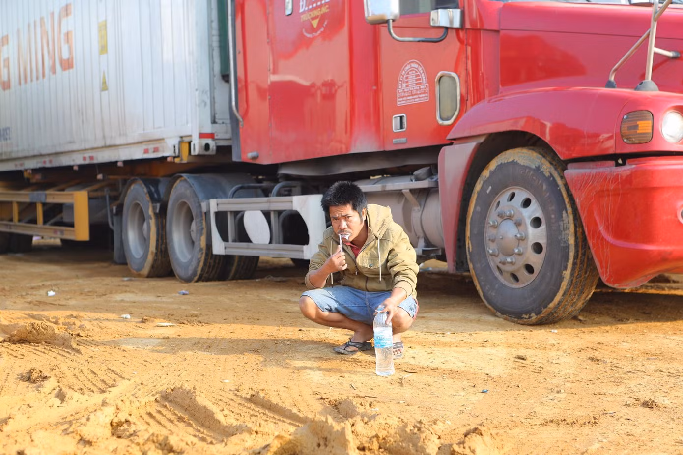 Một số lái xe tiết kiệm nước từ đường ống dẫn nước máy lạnh xe container để đánh răng, rửa mặt -Ảnh: Duy Chiến