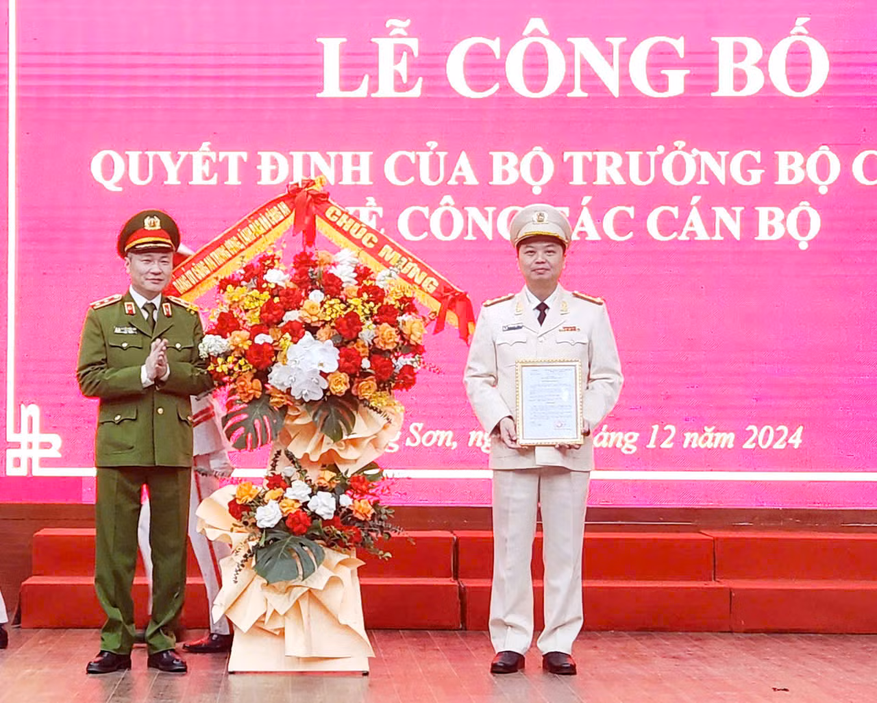 Đại tá Nguyễn Tiến Trung (bìa phải) nhận Quyết định, hoa chúc mừng của lãnh đạo Bộ Công an (ảnh: Duy Chiến)
