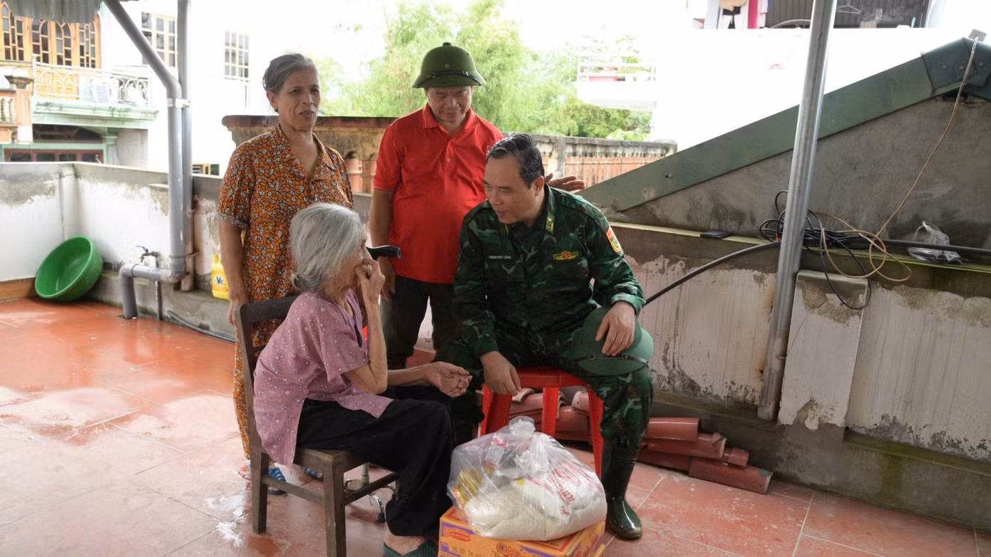 Đại tá Trịnh Hữu Tăng (bìa phải), Chính ủy BĐBP tỉnh Lạng Sơn thăm hỏi, tặng quà người già vùng lũ huyện Tràng Định.