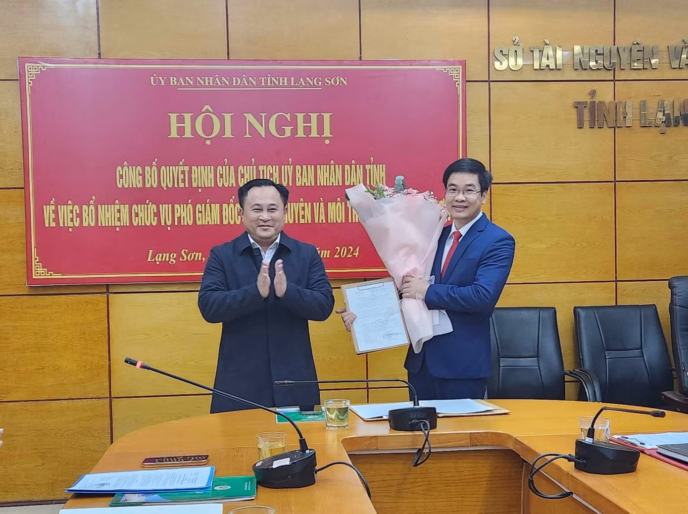 Ông Triệu Đức Minh (bìa phải) nhận Quyết định, hoa từ lãnh đạo UBND tỉnh Lạng Sơn. Ảnh: Duy Chiến