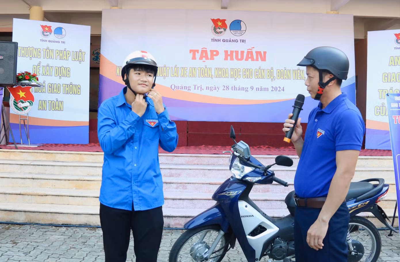 Giáo viên Trường Trung cấp Nghề Giao thông vận tải Quảng Trị hướng dẫn đoàn viên thanh niên đội mũ bảo hiểm đúng cách.
