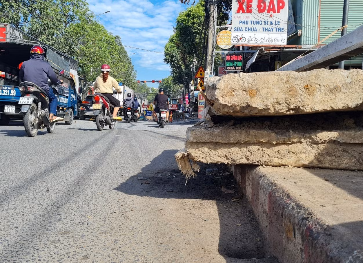 Đơn vị thi công để những tấm bê tông trên cầu Đồng Khởi nhô ra lòng đường không chỉ nguy hiểm cho người tham gia giao thông mà còn chiếm không gian của người đi bộ.