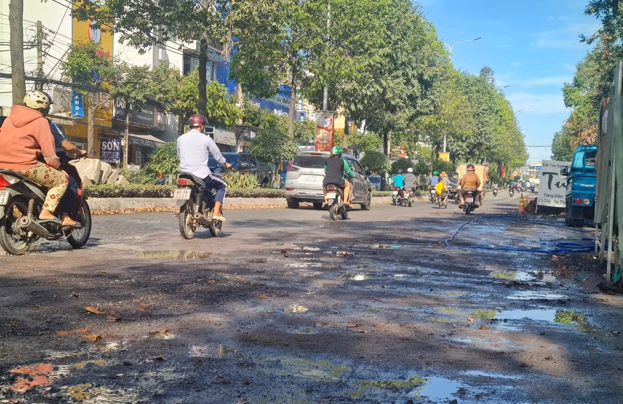 Mặt đường nước chảy trơn trượt gây khó khăn cho người tham gia giao thông.