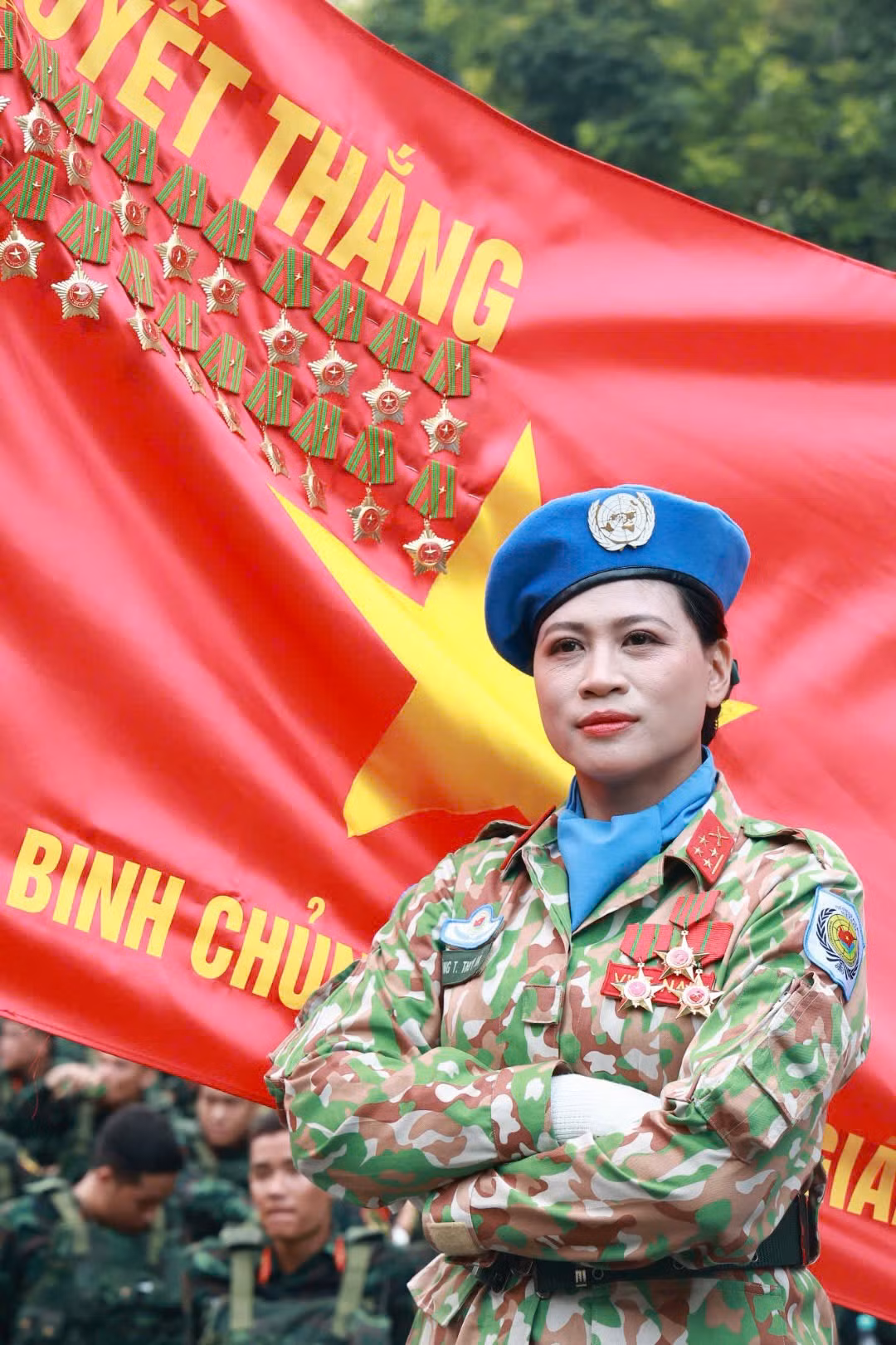 Khoảnh khắc nữ quân nhân thuộc Khối nữ gìn giữ hòa bình Liên Hợp Quốc (trái) và quân nhân thuộc Khối nữ sĩ quan Thông tin trước lá cờ Quyết thắng, thể hiện sự tự hào khi nằm trong đội ngũ lực lượng Quân đội Nhân dân Việt Nam.