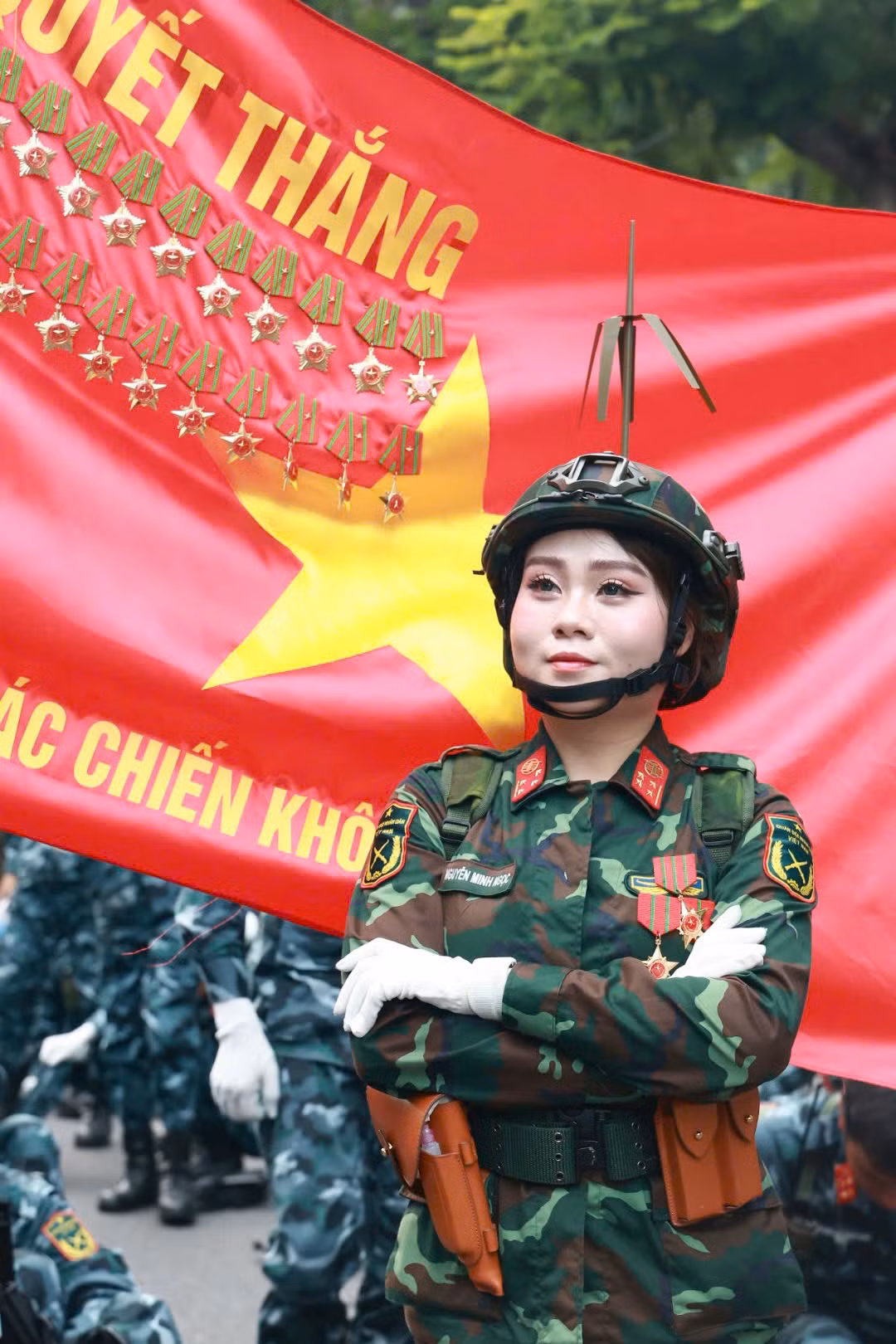 Khoảnh khắc nữ quân nhân thuộc Khối nữ gìn giữ hòa bình Liên Hợp Quốc (trái) và quân nhân thuộc Khối nữ sĩ quan Thông tin trước lá cờ Quyết thắng, thể hiện sự tự hào khi nằm trong đội ngũ lực lượng Quân đội Nhân dân Việt Nam.