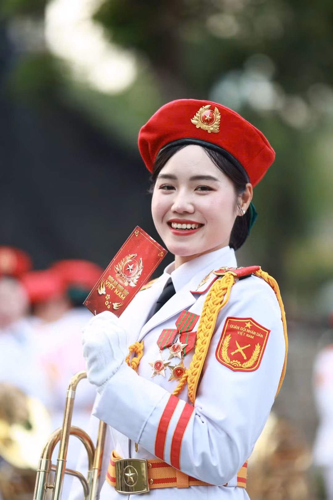 Các nữ chiến sĩ thuộc khối Quân nhạc đứng trang nghiêm trước lá cờ Mặt trận Dân tộc giải phóng miền Nam Việt Nam. Đây là một trong những nữ chiến sĩ đại diện hình ảnh “bông hồng thép” thuộc lực lượng Quân đội Nhân dân Việt Nam.