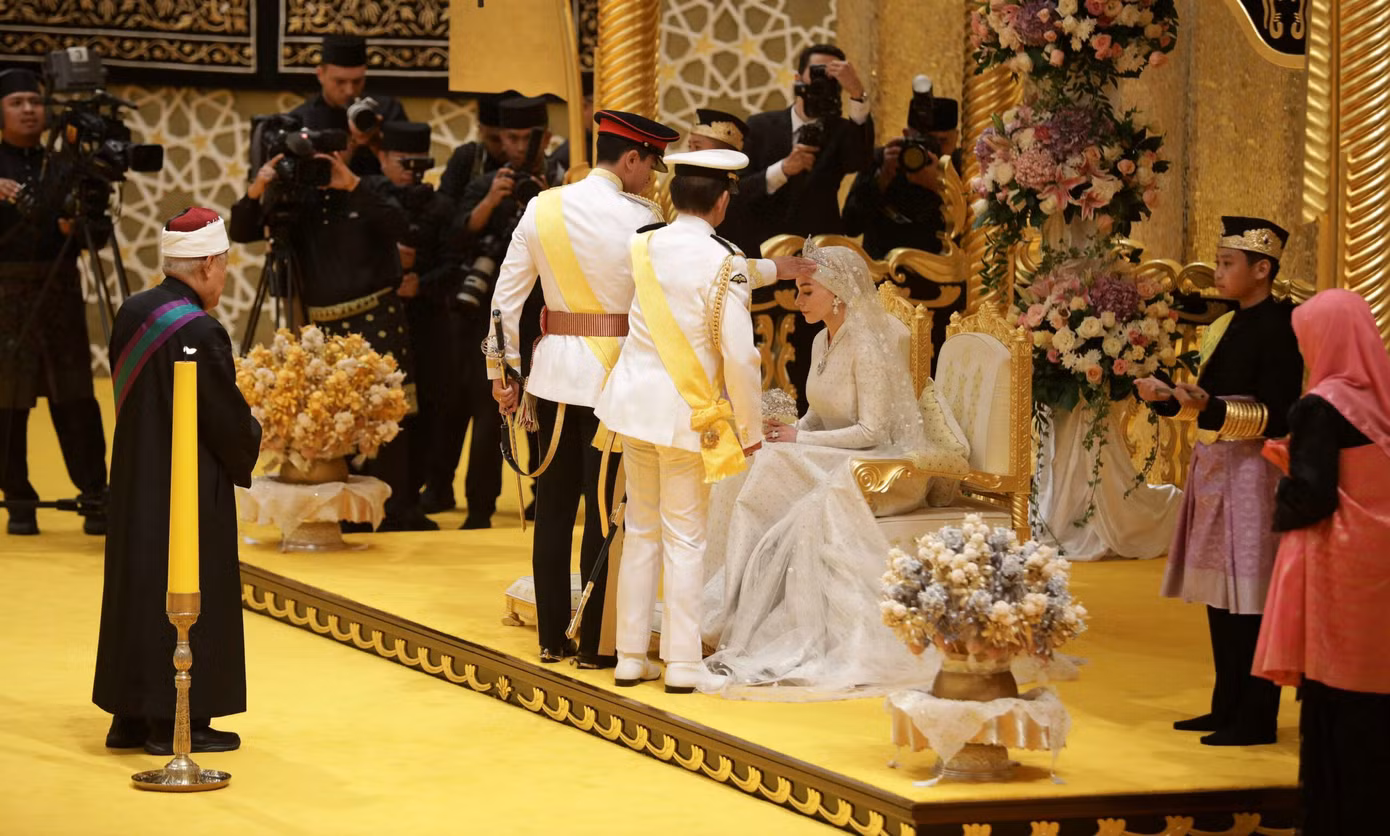 Trong buổi lễ, Anisha được mời vào hội trường, ngồi trang trọng trên ghế. Quốc vương đích thân dẫn Abdul Mateen đến chỗ Anisha, đặt tay lên đầu cô dâu. Đây là một phần trong nghi lễ Menapak Tangan, đánh dấu mối quan hệ hôn nhân.