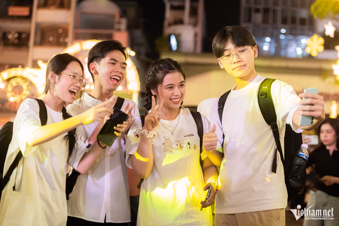 Nhóm bạn của Nhi (quận 7) hào hứng chụp ảnh cùng nhau dưới ánh đèn lung linh. "Chúng mình đã tới nhà thờ Tân Định từ sớm để tránh kẹt xe. Không khí Giáng sinh ở đây rất náo nhiệt và đặc biệt nhà thờ được trang trí rất đẹp", Nhi nói.