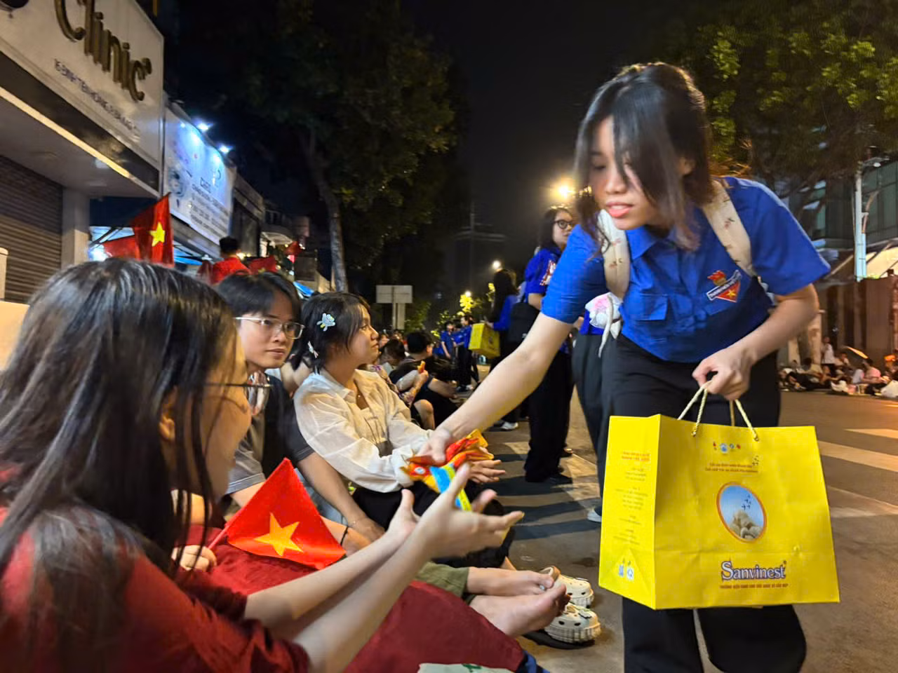 Các đội tình nguyện viên thuộc Đoàn Thanh niên Cộng sản TPHCM phát thực phẩm cho người dân dọc hai bên đường, tiếp sức cho "khối cổ vũ" chuẩn bị cho lễ diễu binh, diễu hành hoành tráng.