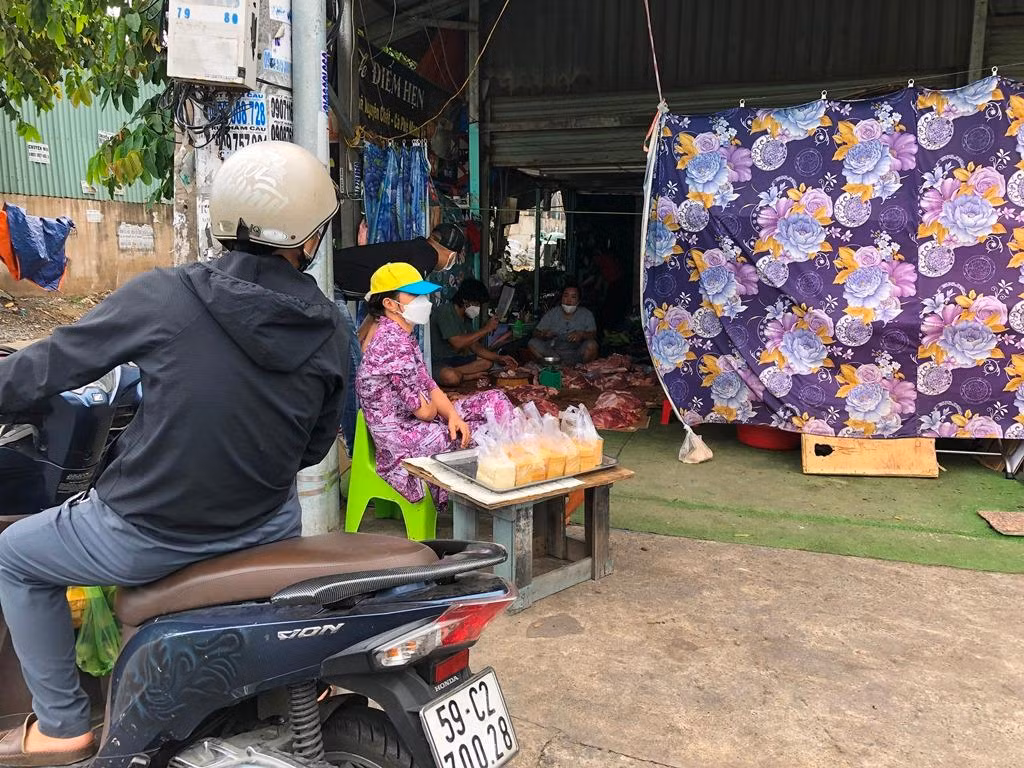 Một gia đình bày thịt heo ngay dưới nền đất trong nhà, ngụy trang bằng tấm màn. Khách chỉ cần kéo màn là mua được thịt dễ dàng. Người bán đậu hủ bên ngoài vừa bán hàng, vừa kiêm nhiệm vụ "báo động" nếu thấy cơ quan chức năng.