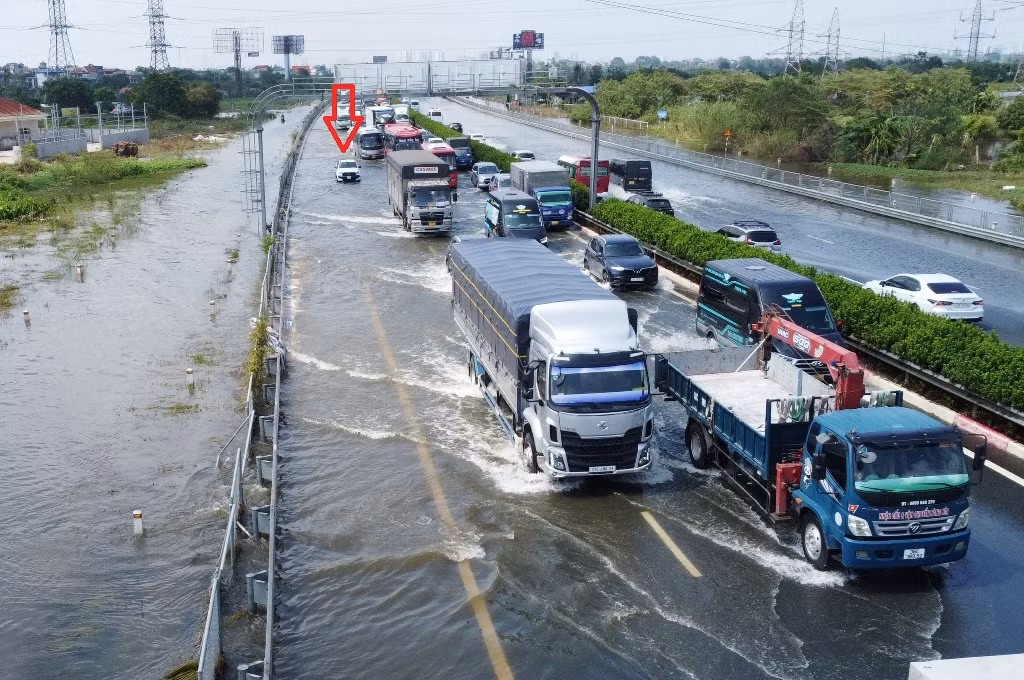 Mặc dù là xe gầm cao (SUV) nhưng do chiều 16/9 nước ngập trên cao tốc Pháp Vân - Cầu Giẽ vẫn ở mức nửa mét nên vẫn có một số xe bị chết máy, đứng yên tại chỗ (mũi tên đỏ).