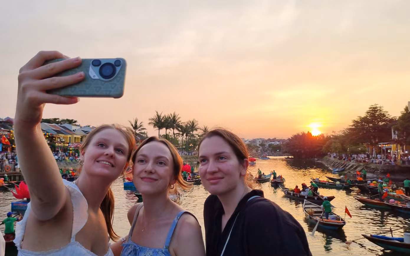Nhóm du khách nước ngoài bắt trọn khoảnh khắc hoàng hôn nơi phố cổ Hội An. Ảnh: Hoài Văn.