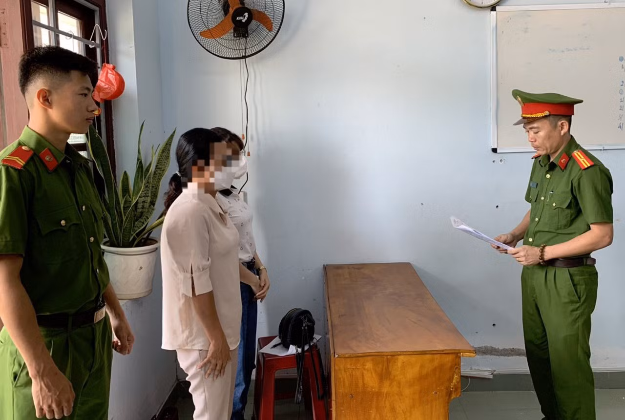 Tống đạt quyết định khởi tố bị can, lệnh cấm đi khỏi nơi cư trú đối với bà H.T.X.T. Ảnh CAQN