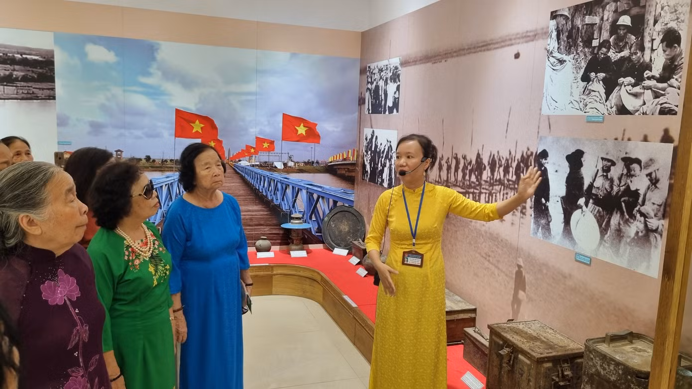 Hướng dẫn viên thuyết minh cho khách tham quan trưng bày chuyên đề Kỷ vật - Ký ức của chiến tranh. Ảnh: Hoài Văn.