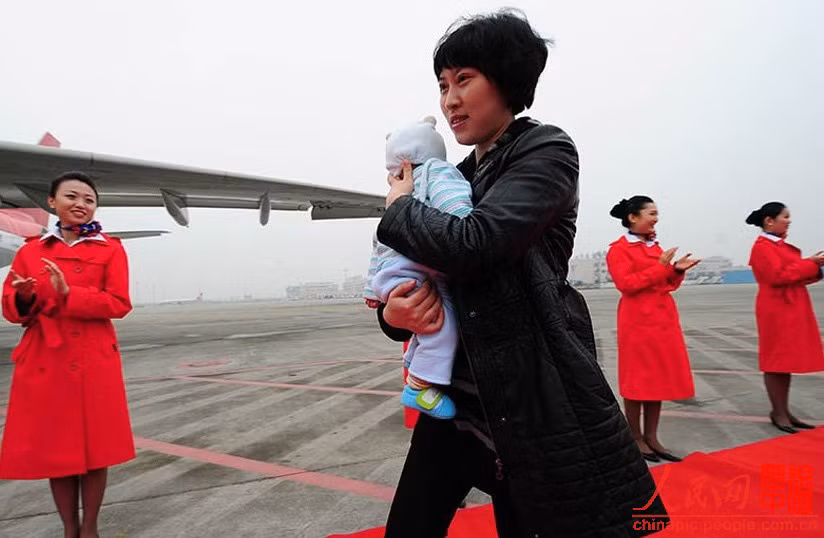 Cô Jiang Min cùng con lên máy bay