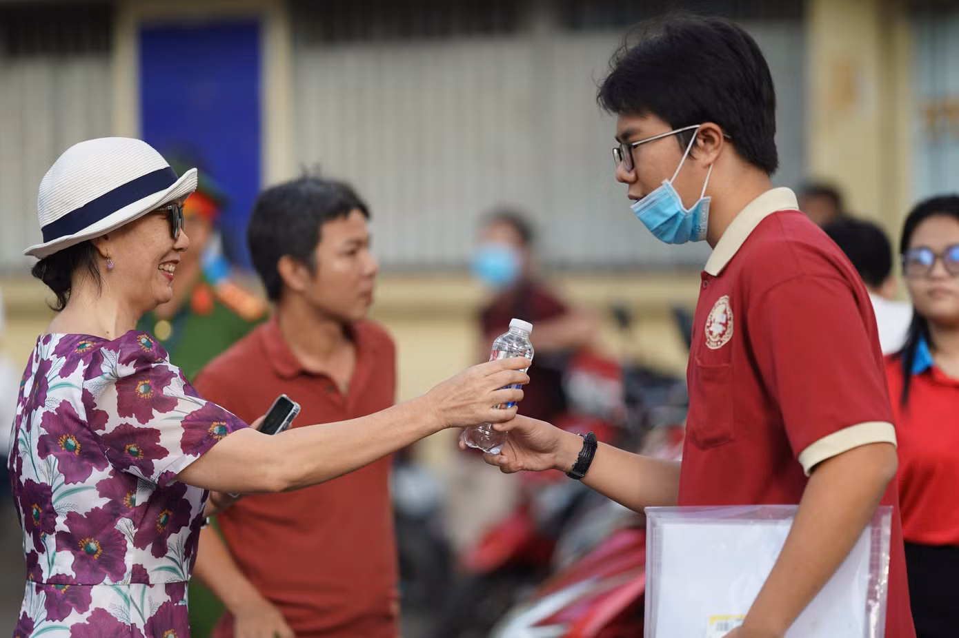 Một phụ huynh khác tiếp nước và dành nhiều lời dặn dò cho con.