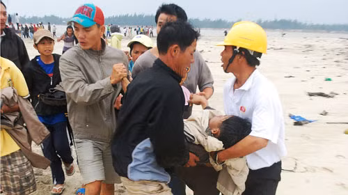 Lực lượng cứu hộ đưa nạn nhân bị chìm tàu vào bờ cấp cứu chiều 25-12 - Ảnh: Tuổi Trẻ