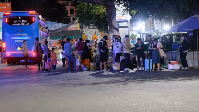 Chị Diễm Phượng (26 tuổi, quê Đắk Nông) cho biết, về quê lúc 29 tháng Chạp và Mùng 5 Tết vào lại Thành phố để chuẩn bị làm việc vào Mùng 7. "Đến bến xe vào khoảng 3h sáng mặc dù còn buồn ngủ nhưng tôi thấy cũng thuận tiện cho việc đi lại, dễ bắt xe về nhà, tránh được kẹt xe", chị Phượng nói. Trong ảnh: Hành khách vừa xuống xe và đang chờ xe taxi hoặc người nhà đến đón